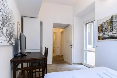 a bedroom with a bed and a desk with a television at Colosseum Apartment with Terrace by NDP rent in Rome