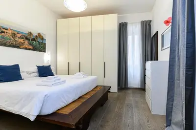 a bedroom with a large white bed and a dresser at Colosseum Apartment with Terrace by NDP rent in Rome