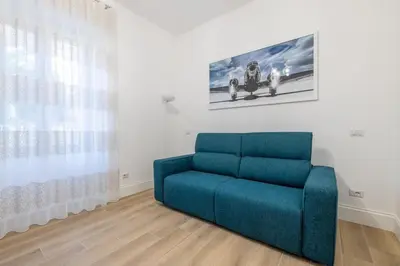 a blue couch in a room with a picture on the wall at Blessed House in Rome