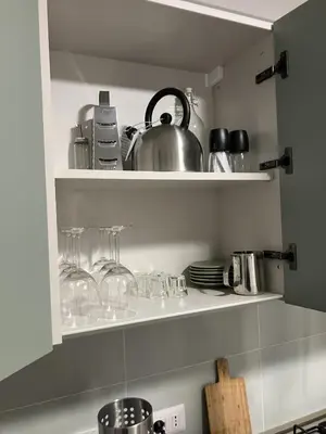 a kitchen shelf with glasses and a tea pot at Blessed House in Rome