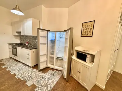 a kitchen with white cabinets and a refrigerator at Your Home at Vatican's doors in Rome