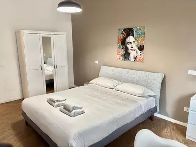 a bedroom with a white bed with a painting on the wall at Your Home at Vatican's doors in Rome