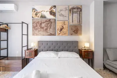 a bedroom with a bed and paintings on the wall at Vatican 2bedr apt in Rome
