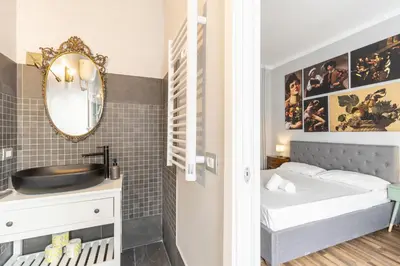 a small bedroom with a bed and a mirror at Vatican 2bedr apt in Rome