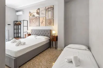 a bedroom with two beds and a table with a night stand at Vatican 2bedr apt in Rome