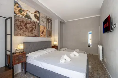 a bedroom with a large white bed and a table at Vatican 2bedr apt in Rome