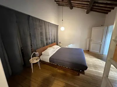 a bedroom with a large bed and a chair at Greci Suite in Rome
