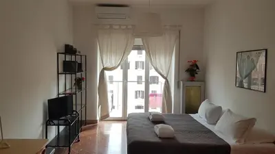 a bedroom with a bed and a large window at Casa Marconi apt in Rome