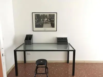 a glass desk with a chair and a picture on a wall at Casa Marconi apt in Rome