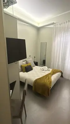 a bedroom with a bed with a television and a chair at Guest House Sinfonia sul Tevere in Rome