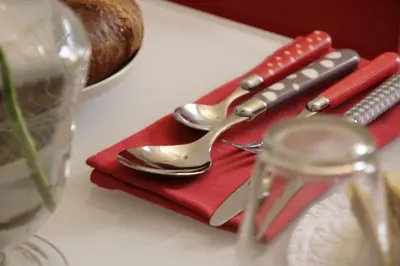 a pair of spoons sitting on a red napkin at Guest House Sinfonia sul Tevere in Rome