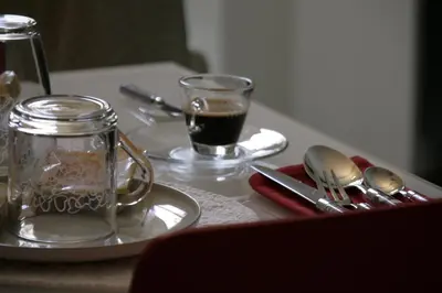 a table with a glass jar and a cup of coffee at Guest House Sinfonia sul Tevere in Rome