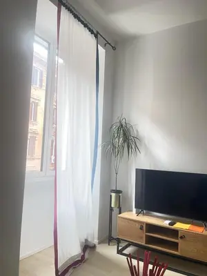 a living room with a tv and a window at Testaccio sul Tevere romantic historical close FAO in Rome