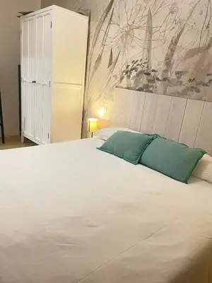 a bedroom with a large white bed with green pillows at Testaccio sul Tevere romantic historical close FAO in Rome