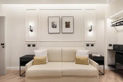 a white living room with a couch and two tables at Piave Boutique Guest House in Rome