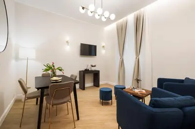 a living room with a blue couch and a table at Volturno Boutique Apartment in Rome