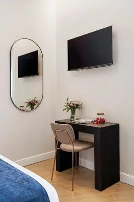 a bedroom with a desk with a tv and a mirror at Volturno Boutique Apartment in Rome