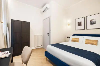 a bedroom with a bed and a desk and a chair at Volturno Boutique Apartment in Rome