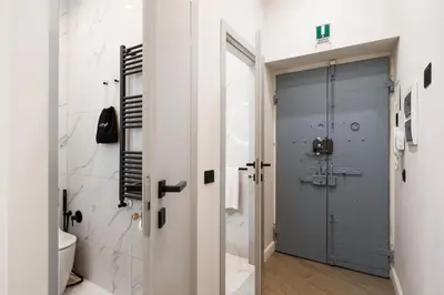 a bathroom with a toilet and a blue door at Volturno Boutique Apartment in Rome