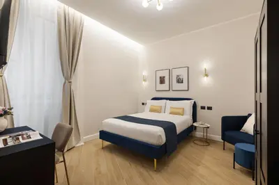 a hotel room with a bed and a chair at Volturno Boutique Apartment in Rome
