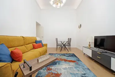 a living room with a yellow couch and a tv at Binario 30 in Rome