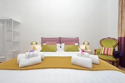 a bedroom with a large bed with two chairs at Binario 30 in Rome