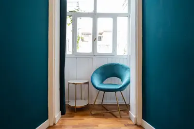 a blue chair in a room with a window at Domus Maggiore Apartment in Rome