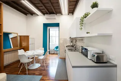 a kitchen with a counter and a table and chairs at Domus Maggiore Apartment in Rome