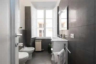 a bathroom with a sink and a toilet and a window at Domus Maggiore Apartment in Rome