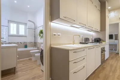 a kitchen with white cabinets and a sink and a toilet at San Pietro Panoramic View in Rome