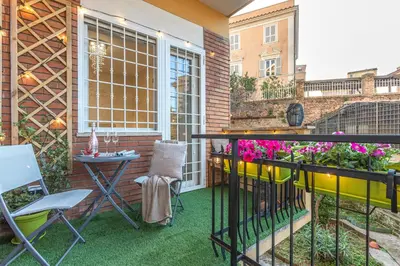a patio with a table and chairs and flowers at San Pietro Panoramic View in Rome