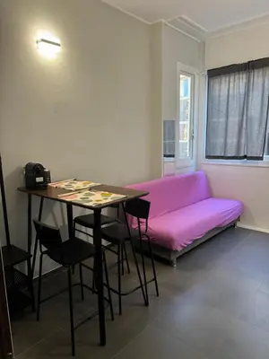 a living room with a pink couch and a table at Al 304 a San Giovanni in Rome