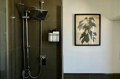 a shower in a bathroom with a picture on the wall at Gioia House in Rome