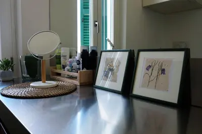 a table with two pictures and a mirror on it at Gioia House in Rome