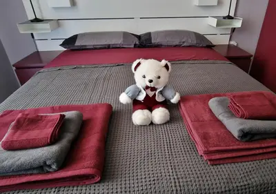 a teddy bear sitting on a bed with towels at Appartamento JazzNBlues House in Rome