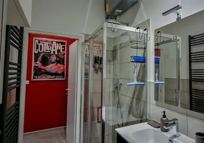 a bathroom with a red door with a poster on the wall at Appartamento JazzNBlues House in Rome