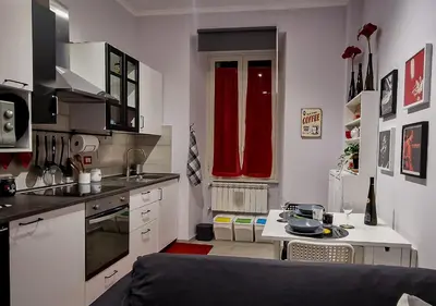 a kitchen with white cabinets and red curtains in it at Appartamento JazzNBlues House in Rome