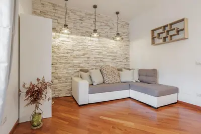 a living room with a couch and a brick wall at Maison Riboty - by 101Flats in Rome
