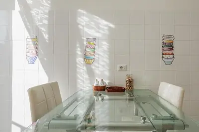 a bathroom with a glass table and two chairs at Maison Riboty - by 101Flats in Rome