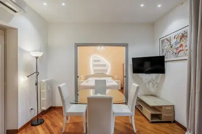 a dining room with a glass table and white chairs at Maison Riboty - by 101Flats in Rome
