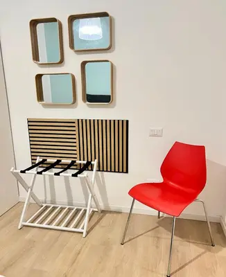 a red chair in front of a wall with mirrors at Flowflat Vatican in Rome
