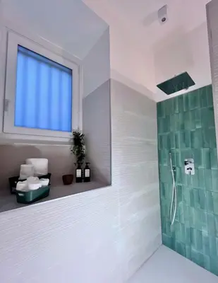 a bathroom with a shower and a sink and a window at Flowflat Vatican in Rome