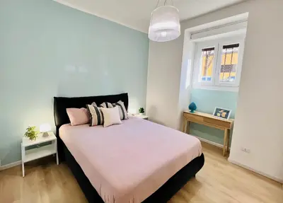 a bedroom with a large white bed with pink pillows at Flowflat Vatican in Rome