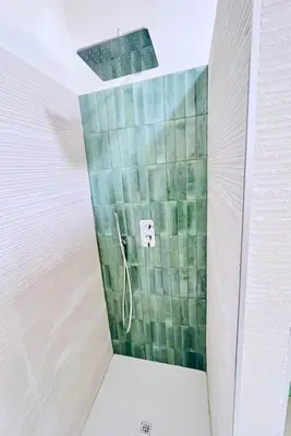 a shower in a bathroom with green tiles at Flowflat Vatican in Rome
