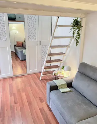 a living room with a couch and a staircase at FlowflatPigneto in Rome