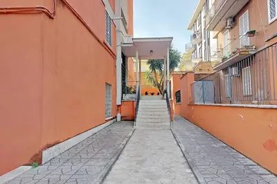 an empty alley with orange buildings and a sidewalk at Lucky Domus Tuscolano in Rome