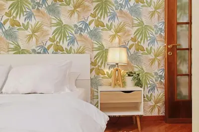 a bedroom with a bed with a tropical wallpaper at Lucky Domus Tuscolano in Rome