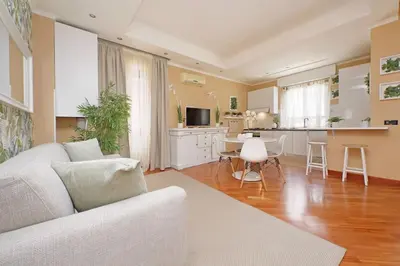 a living room with a couch and a kitchen at Lucky Domus Tuscolano in Rome