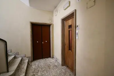an empty hallway with two brown doors and stairs at HC - CloHouse Spacious Flat in Rome