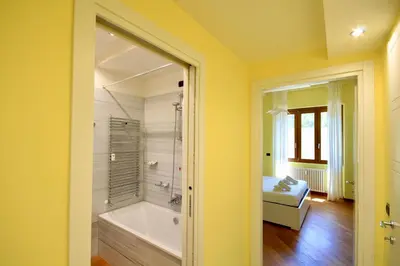 a yellow bathroom with a tub and a bedroom at HC - CloHouse Spacious Flat in Rome